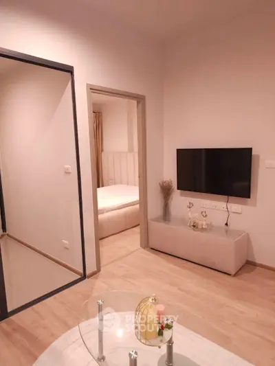 Modern living room with sleek TV setup and cozy bedroom view