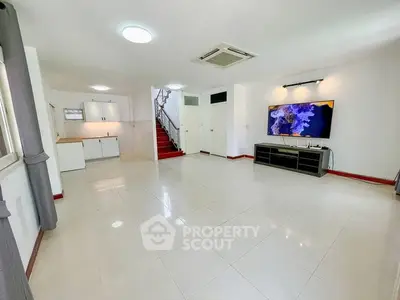 Spacious modern living room with sleek tile flooring and large TV setup