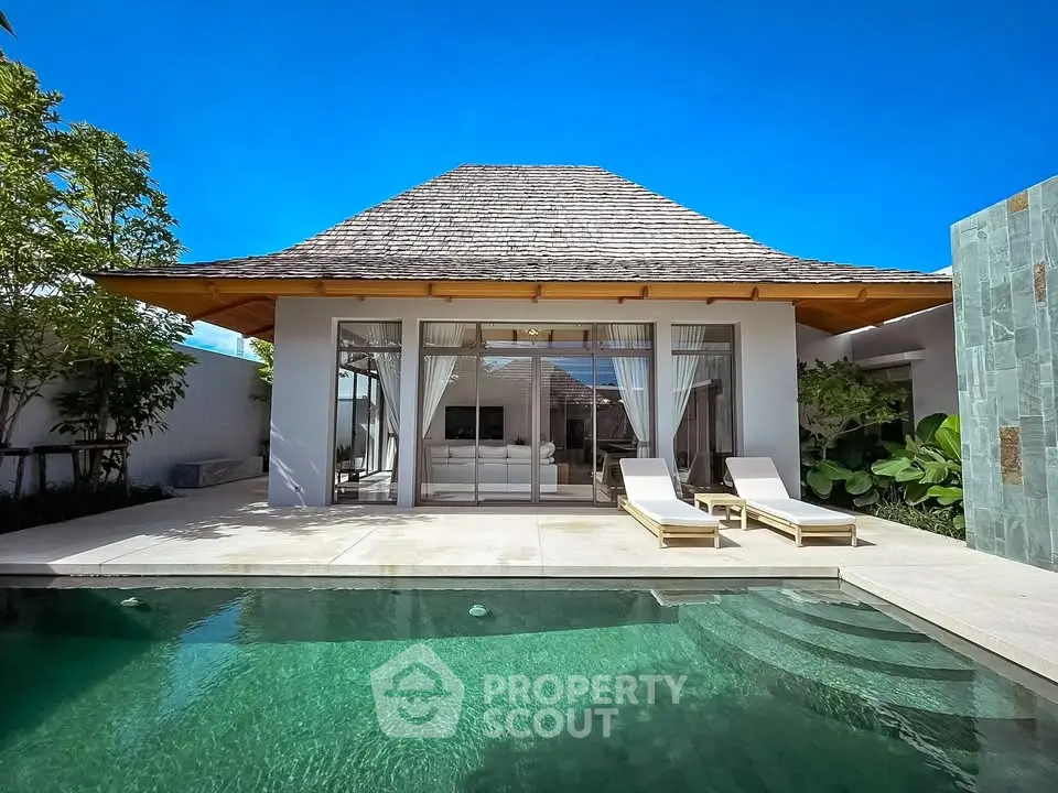Luxurious villa with private pool and sun loungers, perfect for relaxation and tropical living.