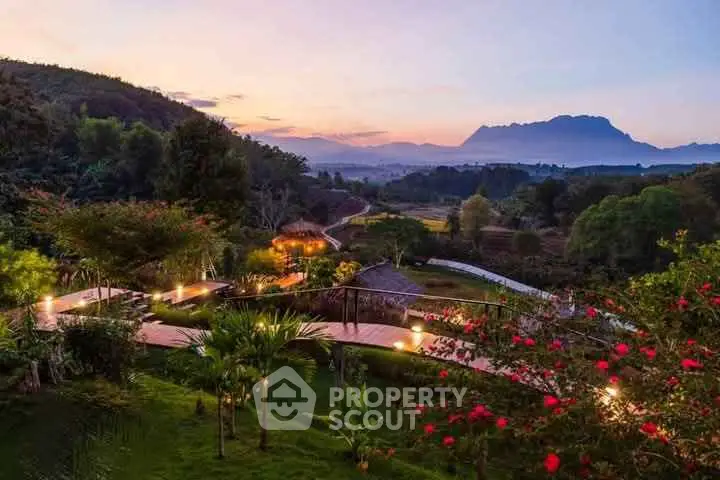 Stunning garden view with lush greenery and mountain backdrop at sunset, perfect for serene living.