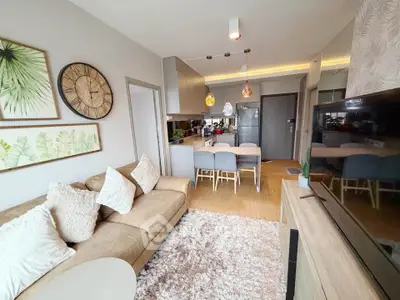 Modern living room with cozy sofa, stylish decor, and open kitchen layout in a chic apartment.