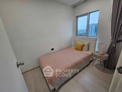 Cozy bedroom with city view, featuring a single bed and modern decor.