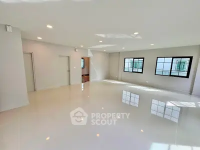 Spacious modern living room with large windows and glossy tile flooring