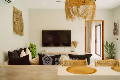 Stylish living room with modern decor and natural accents, featuring a wall-mounted TV and cozy seating area.