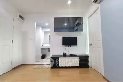 Modern living room with sleek TV setup and wooden flooring in a cozy apartment.