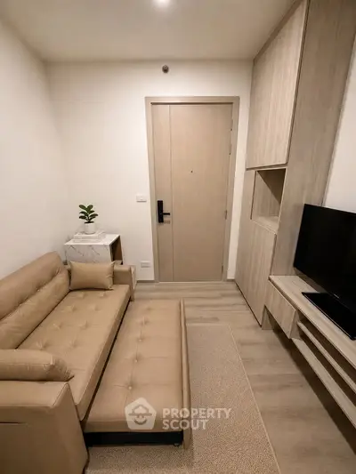 Cozy modern living room with beige sofa and TV unit, perfect for relaxation.