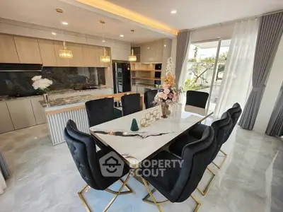 Luxurious dining area with elegant marble table and modern kitchen in open layout design.