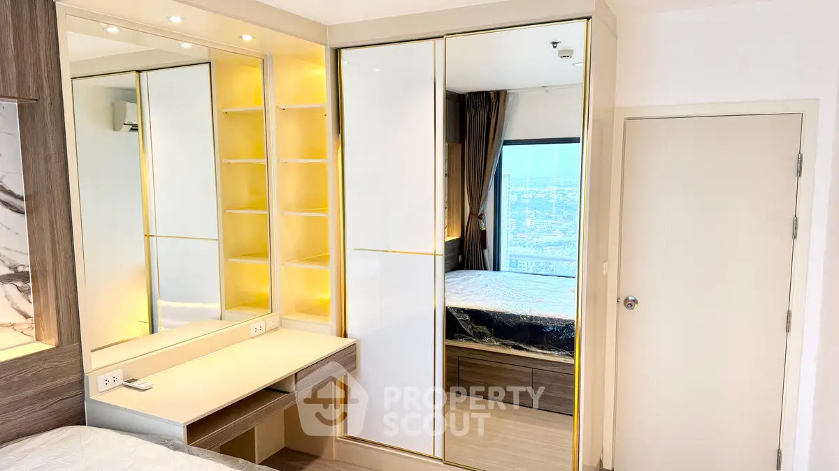 Modern bedroom with built-in wardrobe and city view, featuring sleek design and ample storage space.