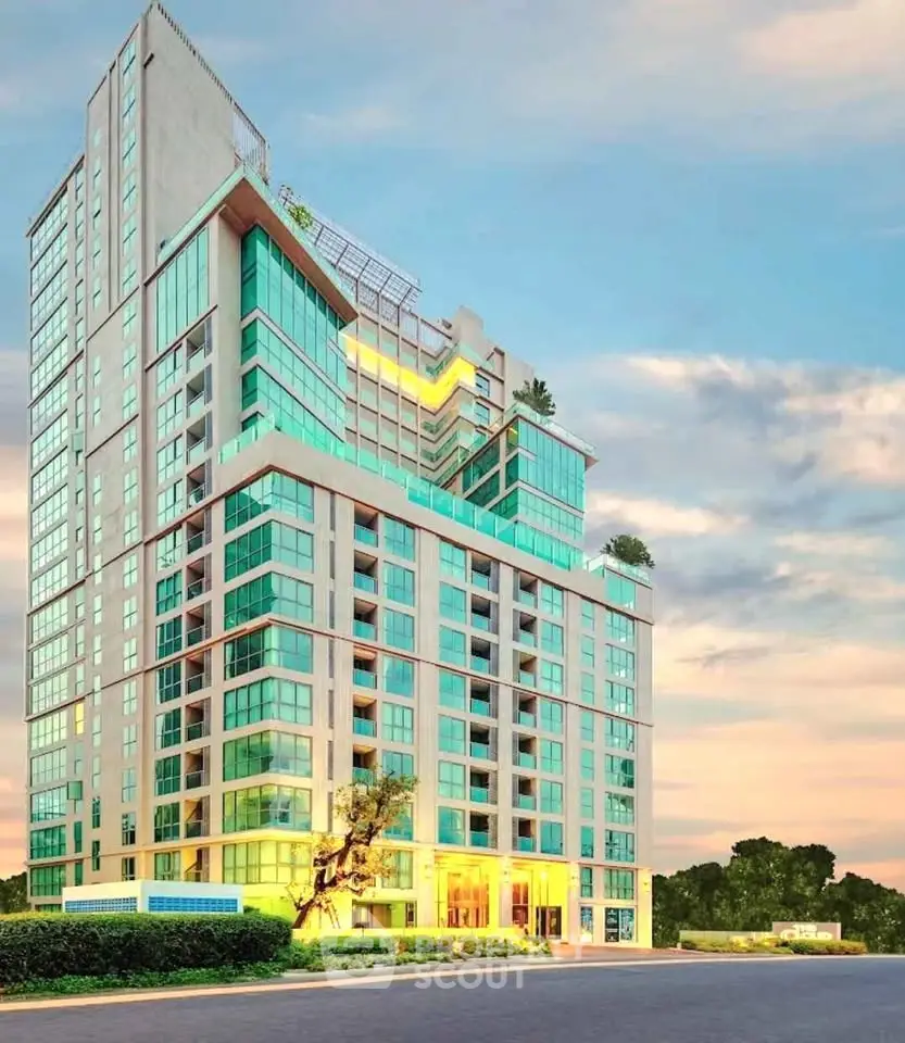 Stunning modern high-rise building with glass facade and lush greenery, perfect for luxurious urban living.