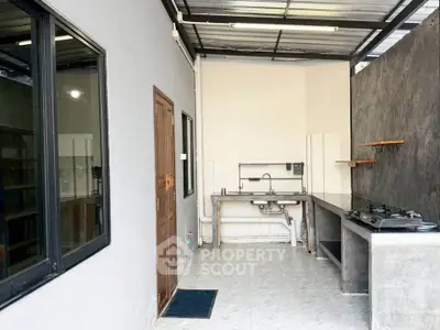 Modern kitchen with open layout and gas stove, featuring sleek countertops and ample natural light.