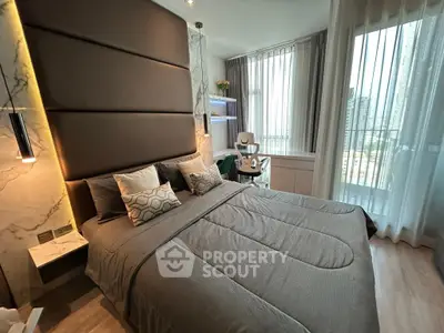 Luxurious bedroom with modern decor and city view, featuring elegant lighting and stylish furnishings.