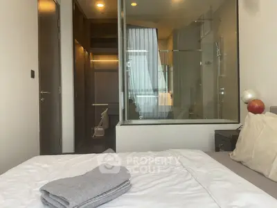 Modern bedroom with glass-walled bathroom and cozy decor