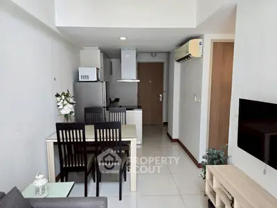 Modern apartment interior with open kitchen and dining area, featuring sleek furniture and contemporary design.