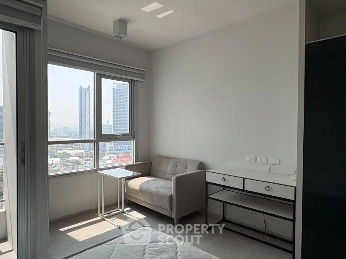 Modern apartment with city view, featuring a cozy living area and natural light.