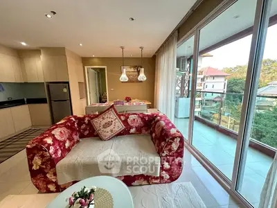 Spacious living room with floral sofa and balcony view in modern apartment