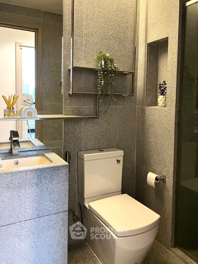 Modern bathroom with sleek fixtures and elegant design, featuring a stylish sink and toilet.