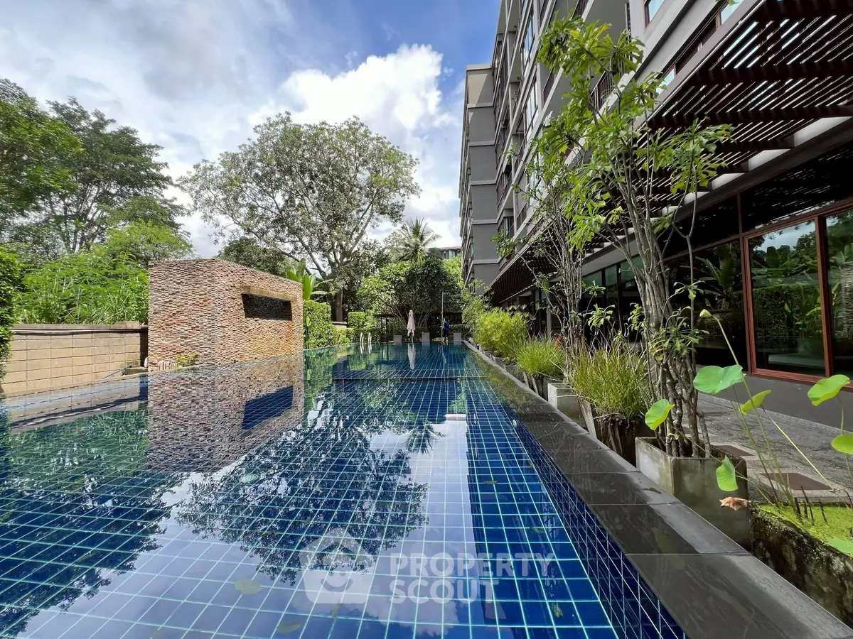 Luxurious modern apartment with stunning outdoor pool and lush greenery, perfect for relaxation and leisure.