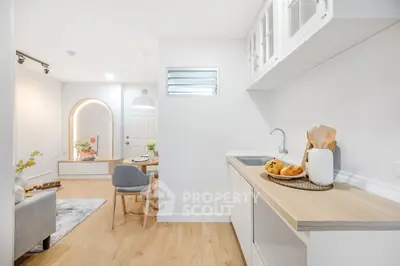 Modern open-plan living room and kitchen with stylish decor and wooden flooring.