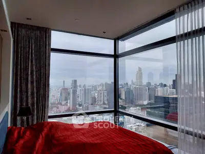 Luxurious bedroom with panoramic city view from floor-to-ceiling windows, featuring modern decor and vibrant red bedding.