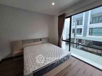 Modern bedroom with large window and natural light in urban apartment