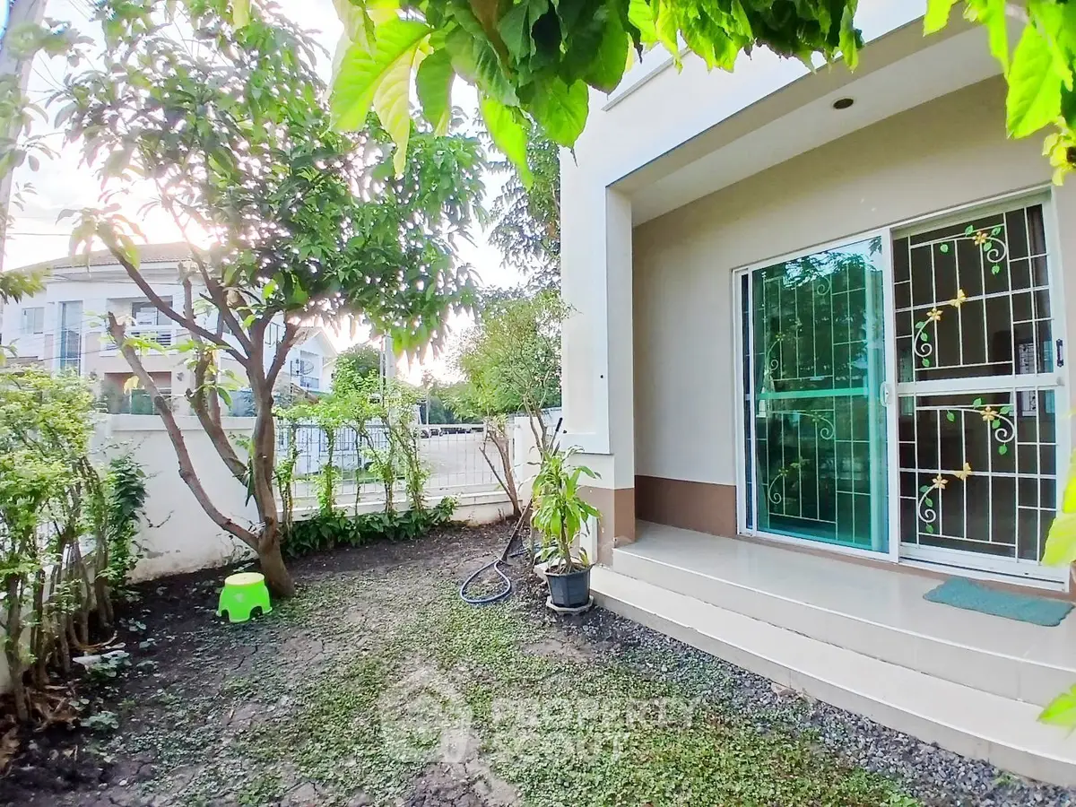Charming garden area with lush greenery and modern patio entrance