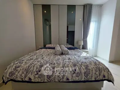 Spacious bedroom with elegant decor and large windows for natural light