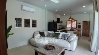 Spacious living room with modern decor and open kitchen layout, perfect for entertaining.