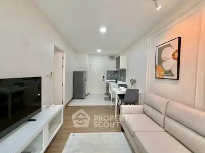 Modern living room with sleek furniture and open kitchen layout in a stylish apartment.