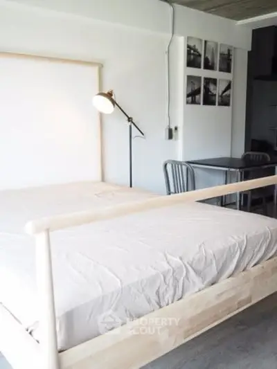 Modern minimalist bedroom with wooden bed frame and stylish lamp