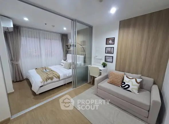 Modern bedroom with glass partition, cozy sofa, and stylish decor