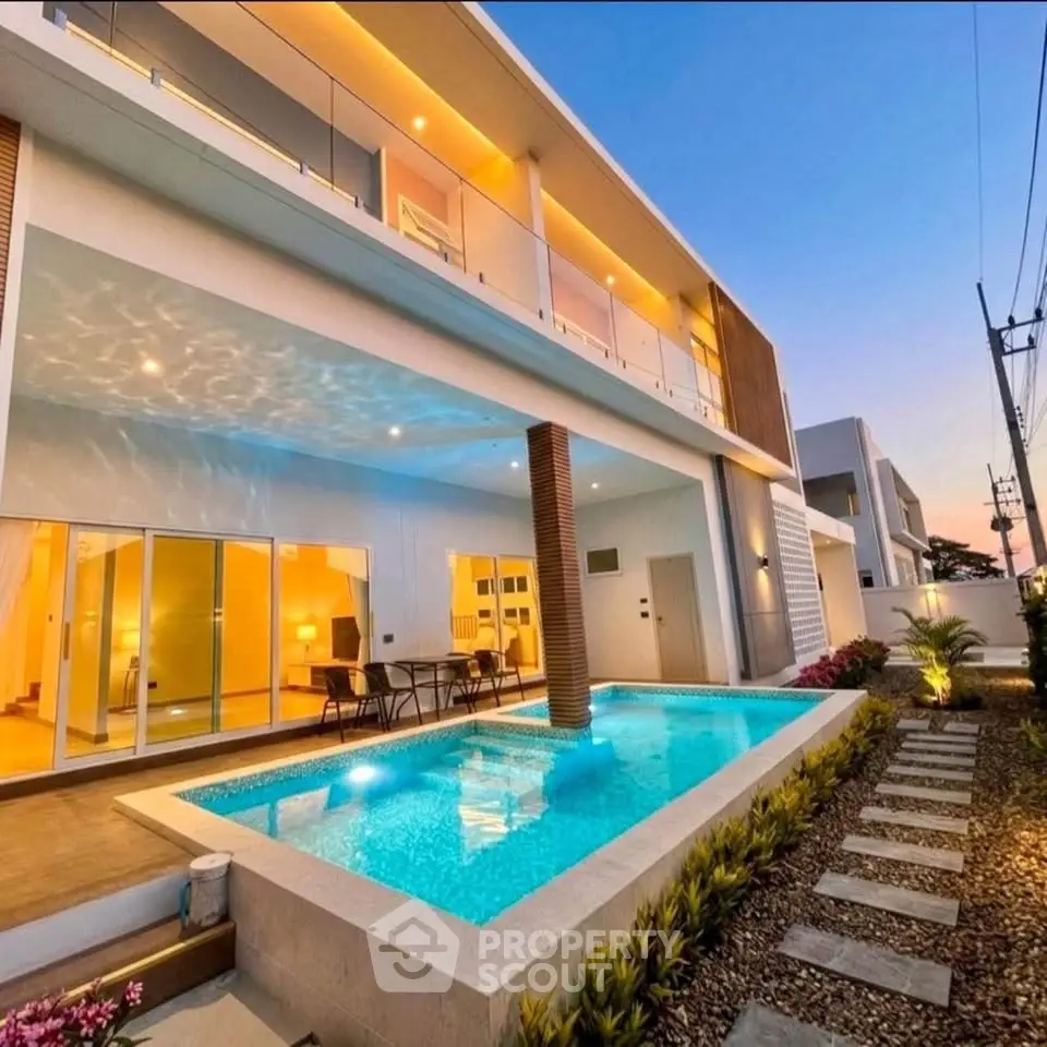 Luxurious modern home with stunning pool and elegant lighting at sunset.