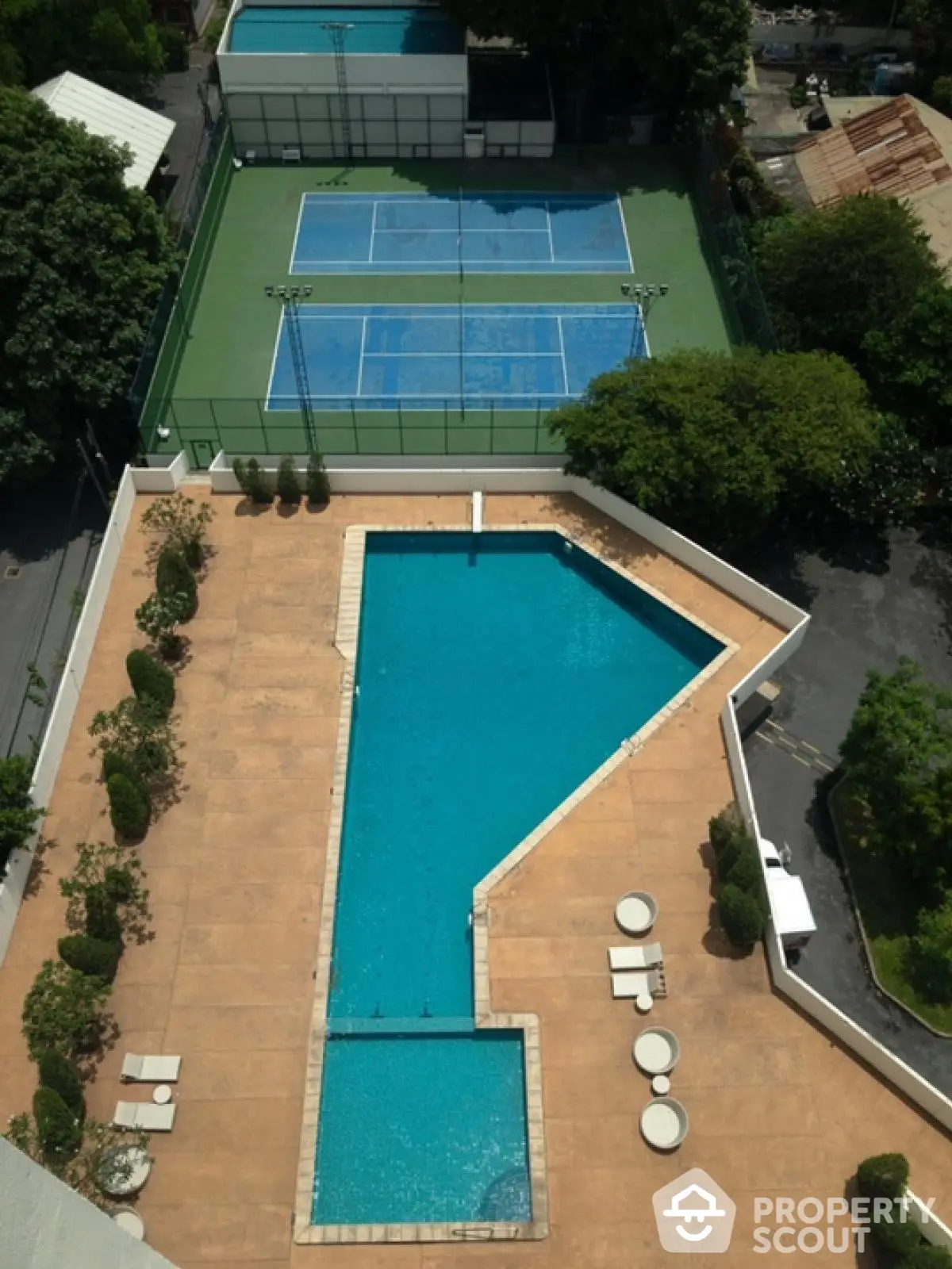 Luxurious apartment complex with tennis courts and swimming pool view