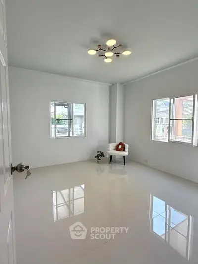 Bright and spacious room with modern lighting and large windows in a minimalist home.