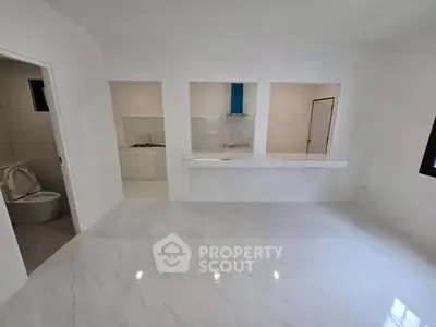 Spacious white interior with marble flooring and open kitchen layout