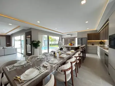 Luxurious open-plan kitchen and dining area with pool view, modern appliances, and elegant decor.
