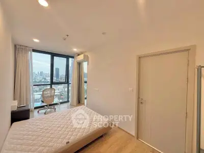 Modern bedroom with city view, featuring a minimalist design and large windows for natural light.