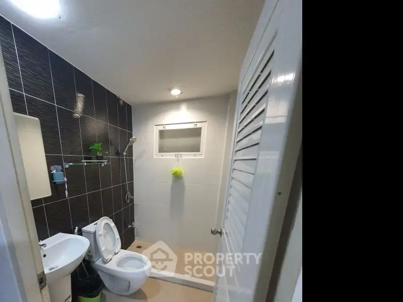 Modern bathroom with sleek black tiles and white fixtures