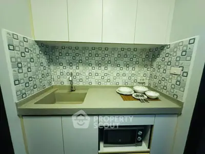 Modern compact kitchen with sleek design and microwave