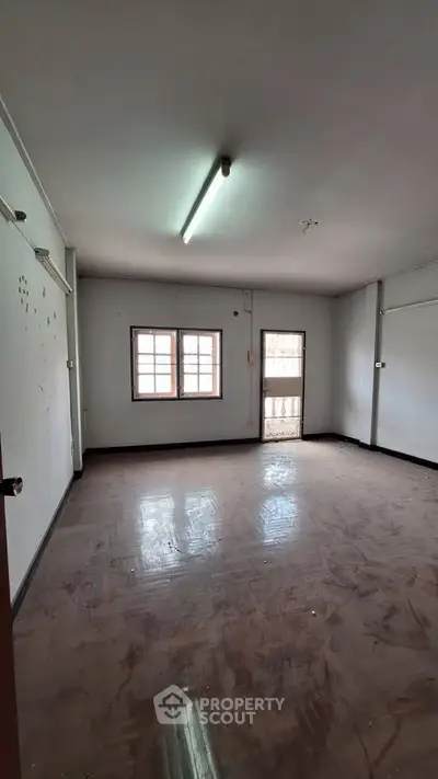 Spacious empty room with large windows and natural light, ideal for customization.