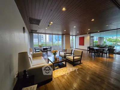 Spacious and elegant living room with modern furniture and large windows offering a garden view.