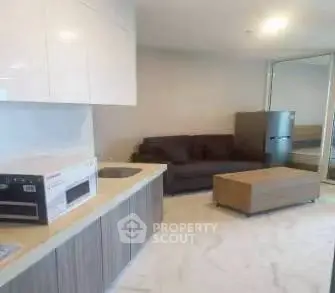 Modern open-layout kitchen with sleek cabinetry and cozy living area