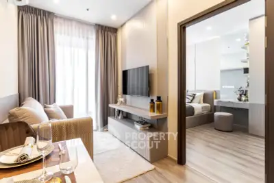 Modern living room with cozy seating and stylish decor adjacent to a chic bedroom.