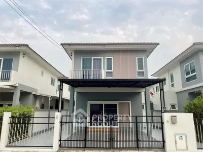 Modern two-story house with sleek design and spacious driveway in suburban neighborhood.