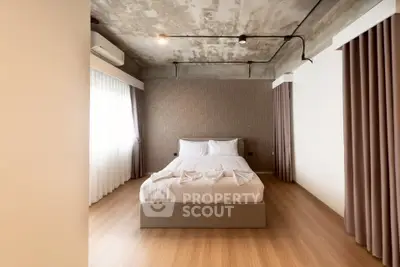 Modern minimalist bedroom with industrial ceiling and cozy ambiance