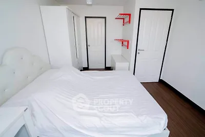 Modern minimalist bedroom with white furniture and wooden flooring