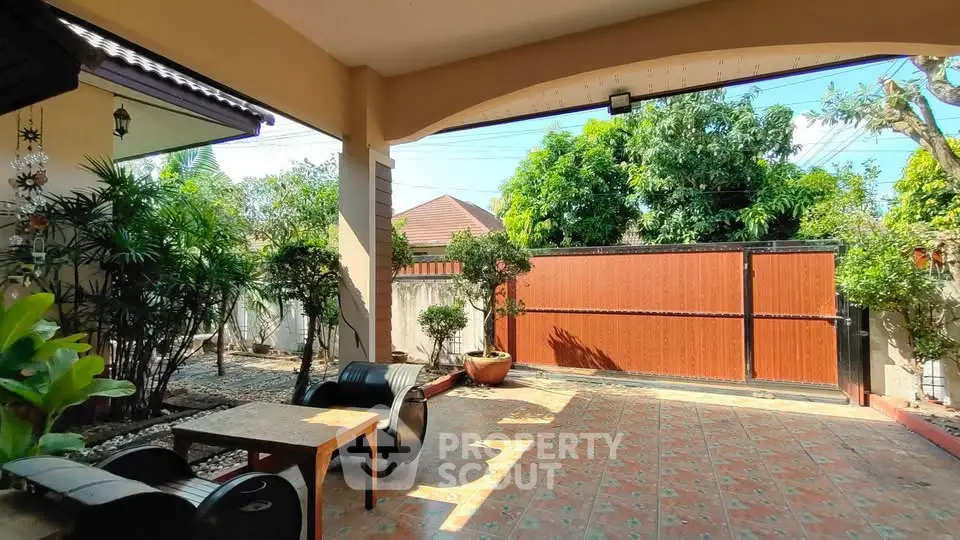 Charming outdoor patio with tiled flooring and lush greenery, perfect for relaxation and entertaining.