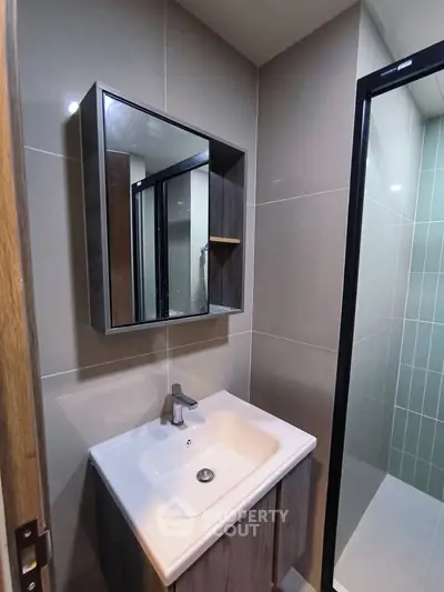 Modern bathroom with sleek sink and mirror in stylish apartment.