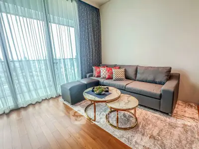 Stylish living room with modern sofa, chic coffee table, and floor-to-ceiling windows offering natural light.
