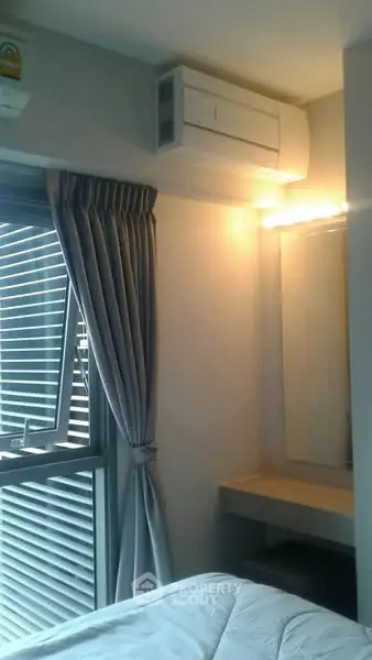 Cozy bedroom with air conditioning and window view, perfect for relaxation.