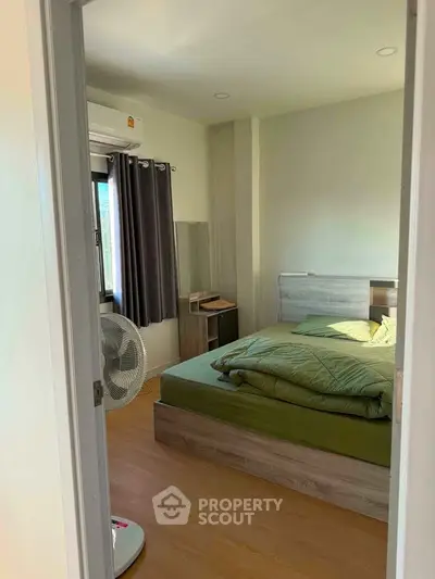 Cozy bedroom with modern furnishings and natural light, perfect for relaxation and comfort.